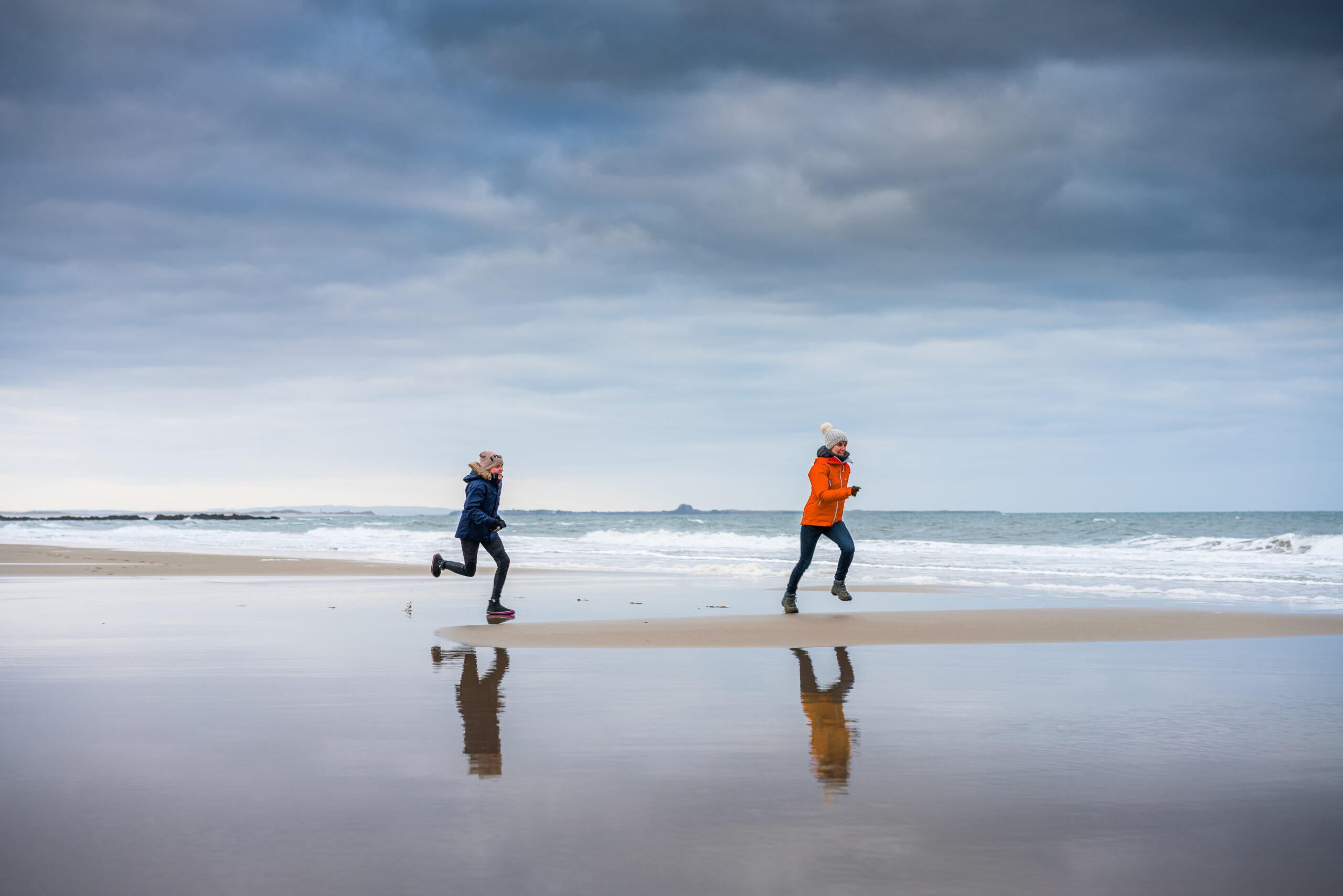 Daughter,Chasing,Her,Mother,On,The,Beach